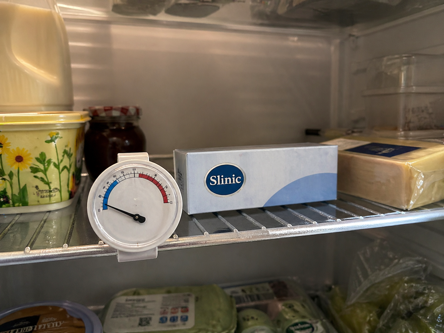 Fridge thermometer inside a home refrigerator showing the correct 2 to 8 degree storage temperature for Mounjaro