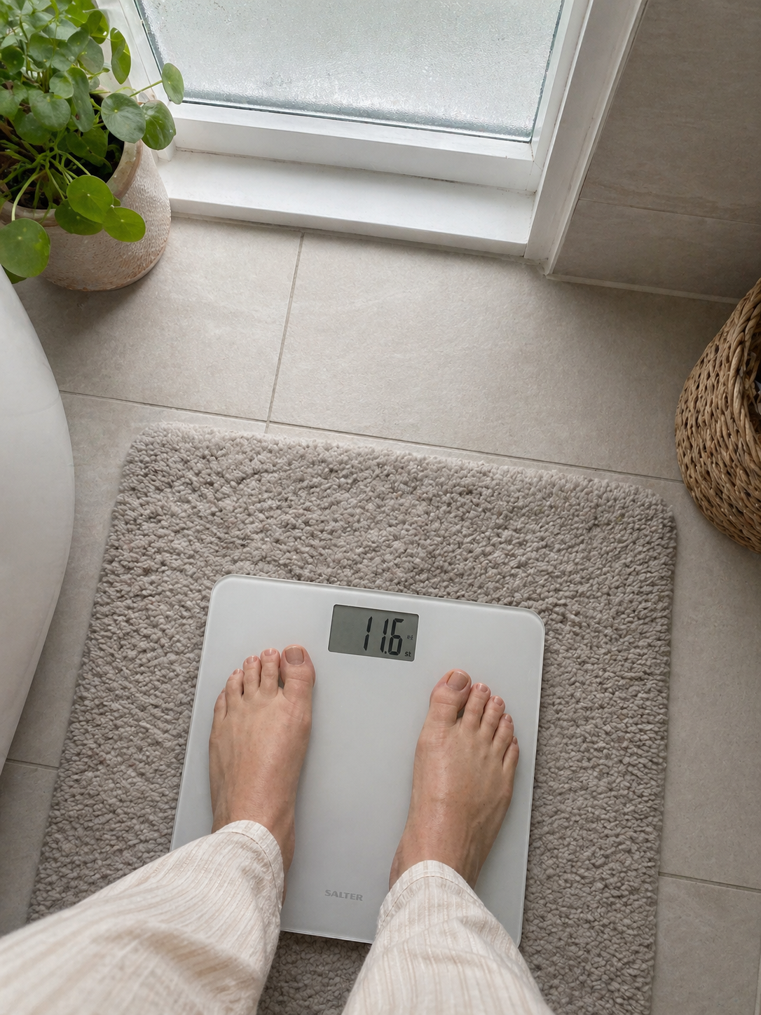 Mounjaro patient stepping on the bathroom scales at the end of month one of treatment